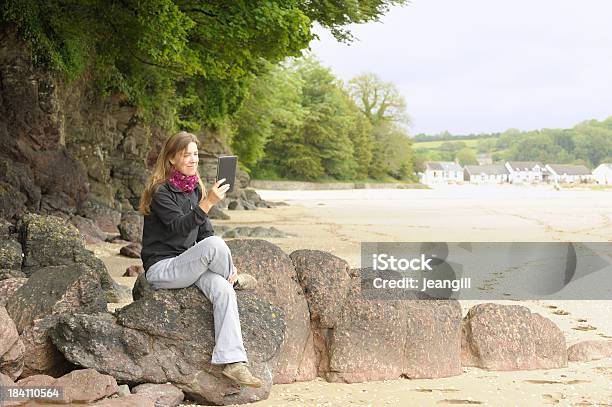 Mature Woman Outdoors With Electronic Tablet Stock Photo - Download Image Now - Beach, Using Digital Tablet, 40-44 Years