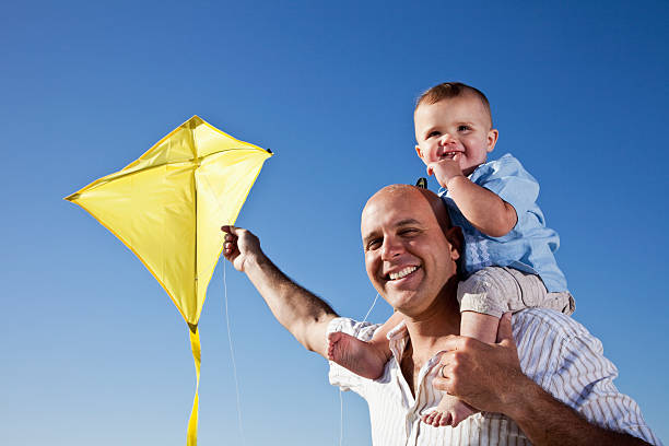 istock Father with little boy on shoulders flying kite 184110771