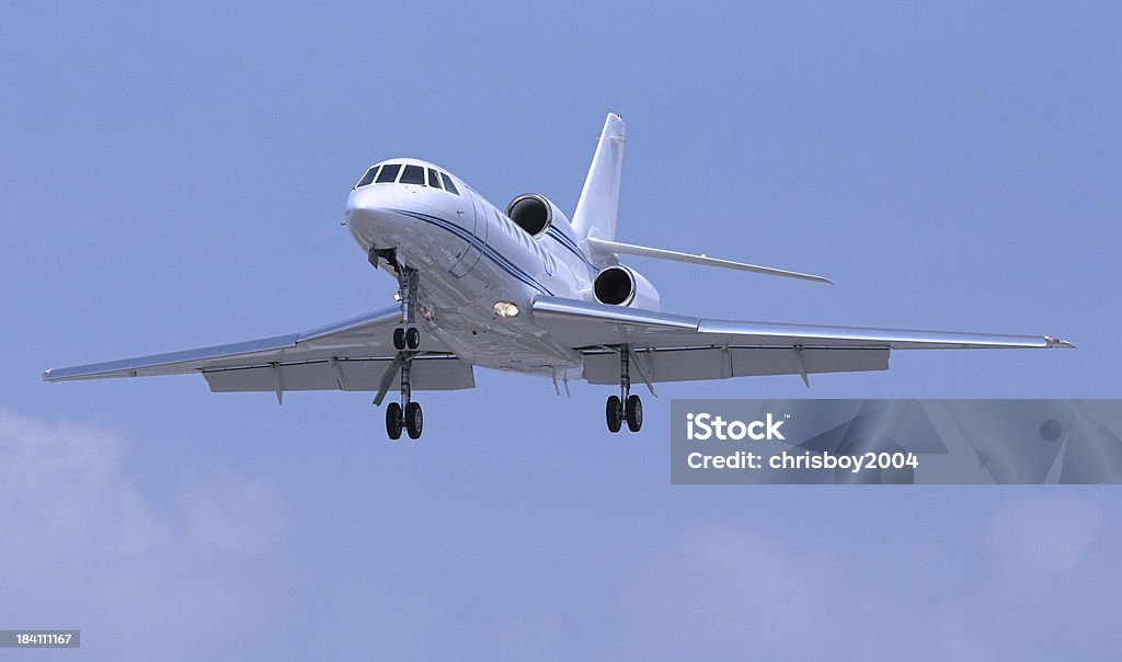 Small jet recently taken off with wheels still hanging out "small jet preparing for landing, or having just taken off" Air Vehicle Stock Photo