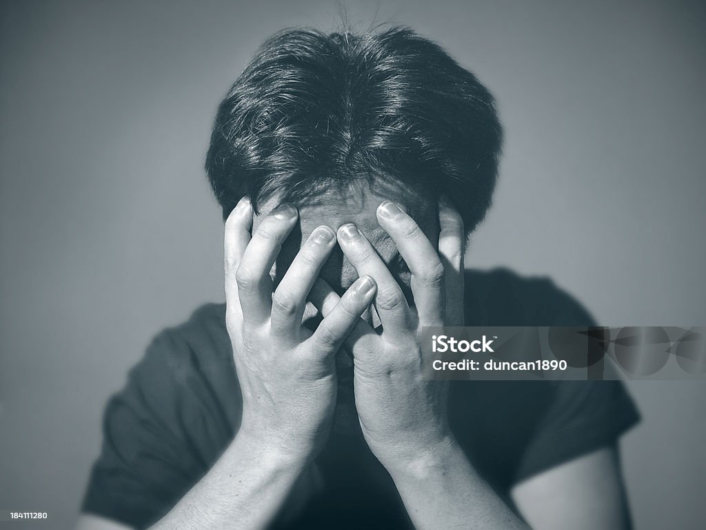 Depression "Portrait of a depressed young man, covering his face with his hands.You can find more photographs of this model in" 20-24 Years Stock Photo