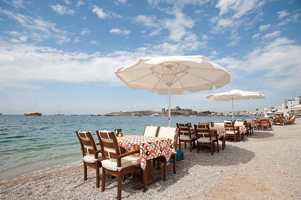 seaside ristorante con ombrelloni. - umbrella poolside table dining foto e immagini stock