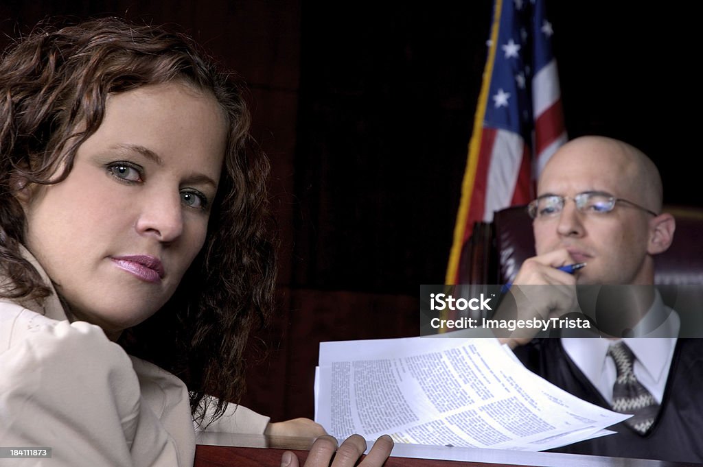 Legal Documents A female lawyer presents court papers to the judge.  Judge is out of focus. Affidavit Stock Photo
