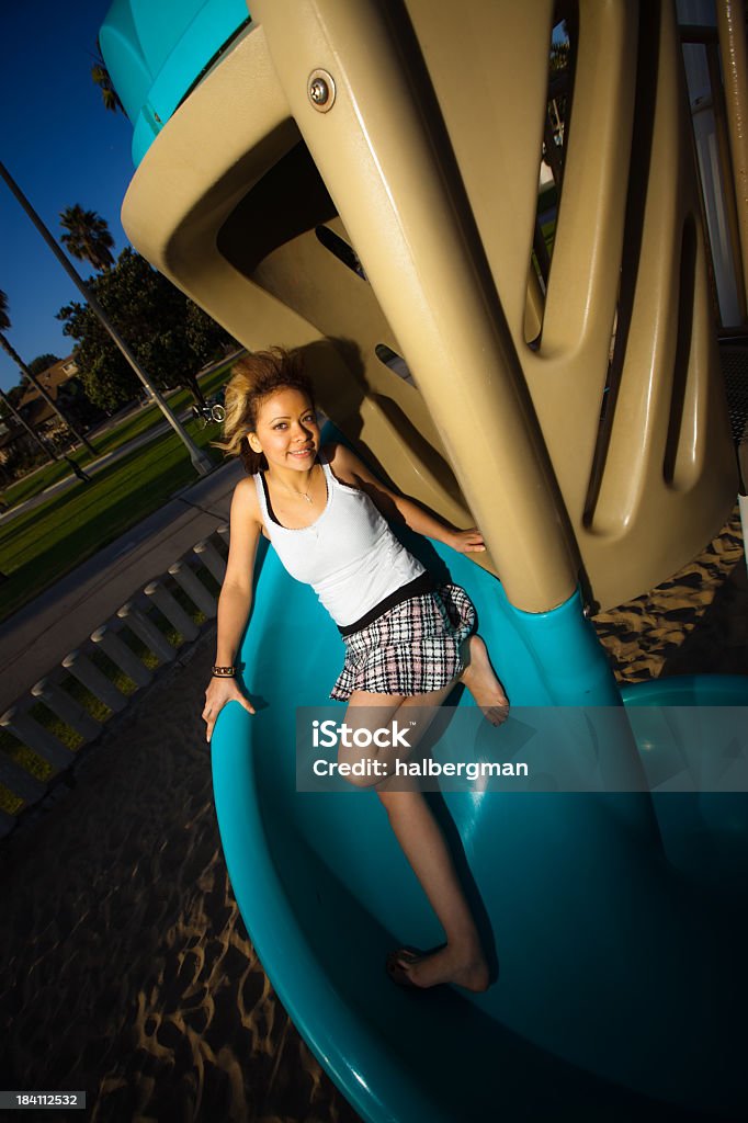 Adolescente ragazza in un parco giochi diapositiva - Foto stock royalty-free di Adolescente