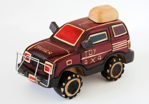 Wooden car in children hand protection safety and insurance. Ecological toys for children concept