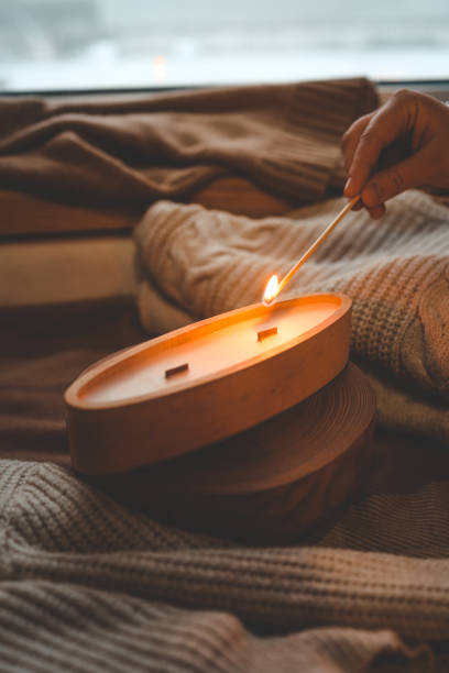 istock A match lights a candle in wood, stylish interior 1841134441