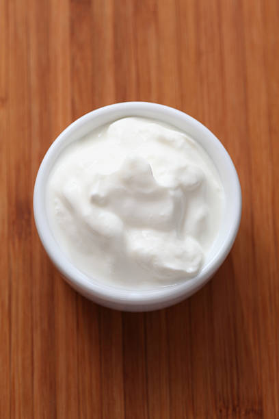 istock Sour cream in a bowl on a wood table 184113557