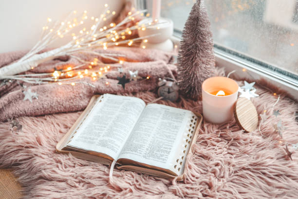 istock Open Bible in cozy pink winter home morning atmosphere 1841140741