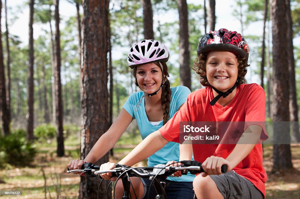 Fratelli biciclette equitazione - Foto stock royalty-free di Ragazze adolescenti