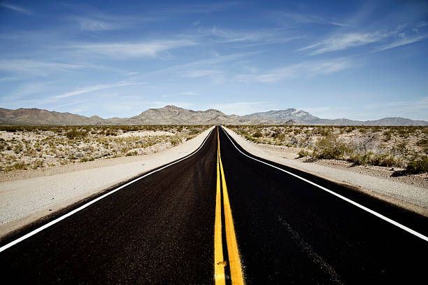mojave desert highway Wide angle landscape image of a newly paved stretch of rarely traveled desert highway between interstate 15 and Searchlight Nevada. rabbit brush stock pictures, royalty-free photos & images