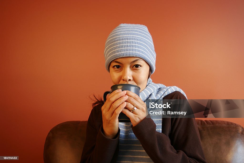 Donna sorseggiando una bevanda calda - Foto stock royalty-free di Abbigliamento casual