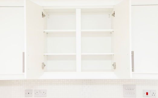 An empty cupboard in a new white kitchen