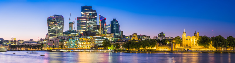 The futuristic skyscrapers of the City Financial District glittering at sunset overlooking the River Thames at Tower, London.