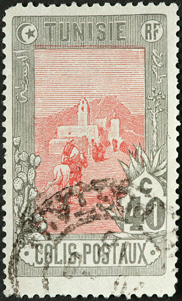 istock rider approaching a walled Tunisian city on old stamp 184115604