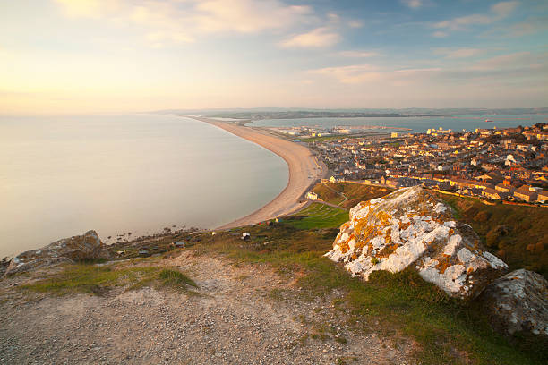 Chesil Beach and Weymouth The view over Weymouth on the Dorset coast with Chesil Beach running off into the distance. bill of portland stock pictures, royalty-free photos & images