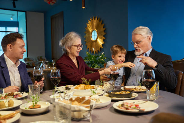 istock Aged man having fun with little boy while celebrating Christmas in restaurant 1841163417