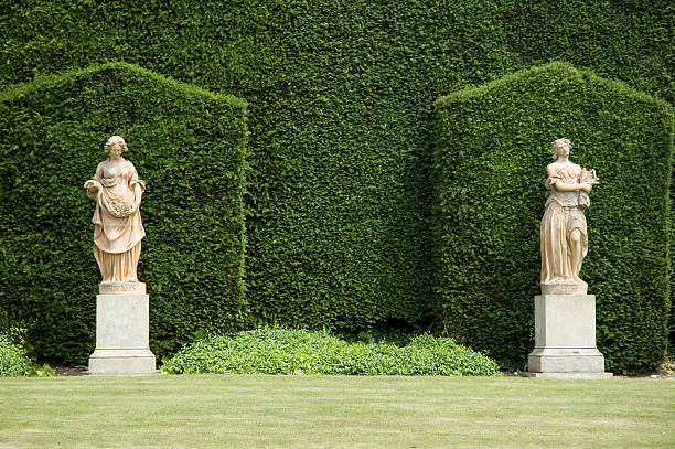 Two marble statues against hedges in an English garden Classical garden topiary stock pictures, royalty-free photos & images