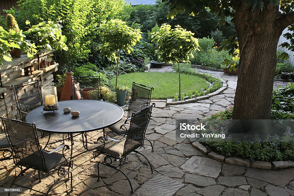 Landscaped Back Yard Patio, Flower Garden with Natural Paving Stones Subject: A garden and patio in the warm afternoon sun Shade Stock Photo