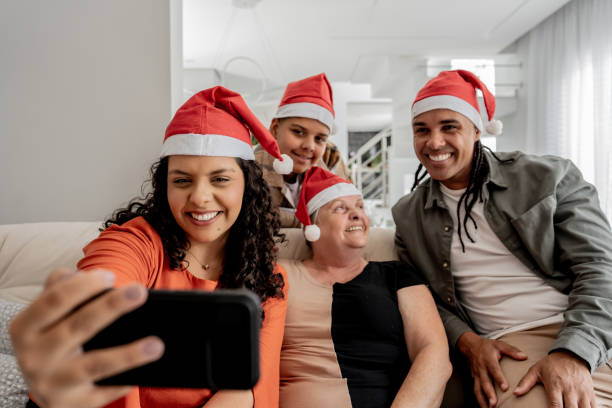 Family making video call at Christmas Family making video call at Christmas - Santa Claus Hat natal brazil stock pictures, royalty-free photos & images