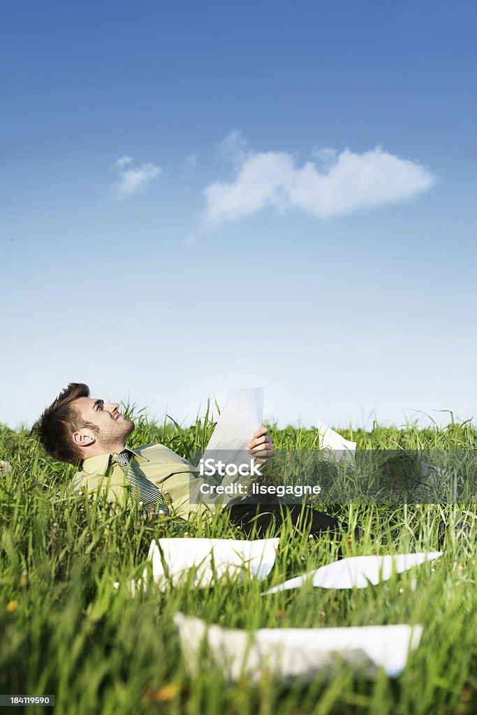 Relaxing outdoors "Businessman in a meadow,reading papers" Activity Stock Photo