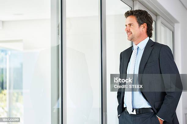 Executive Looking Out Through A Glass Door Stock Photo - Download Image Now - 30-39 Years, 40-49 Years, Adult