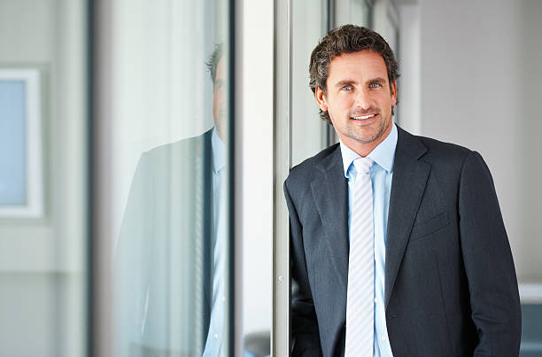 istock Mature executive standing against door 184120103