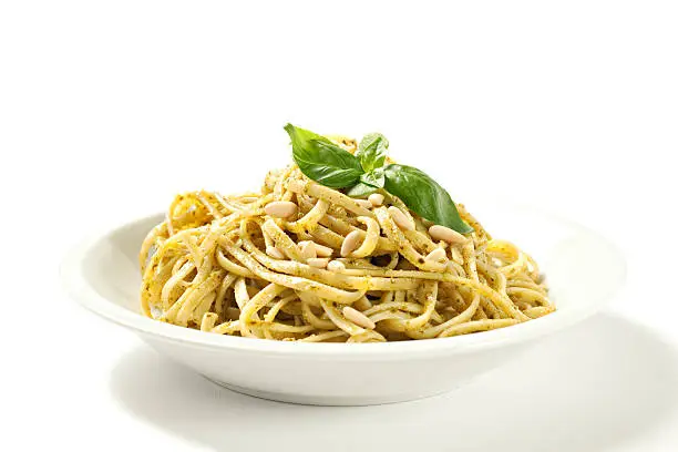 Spaghetti with pesto sauce isolated on white