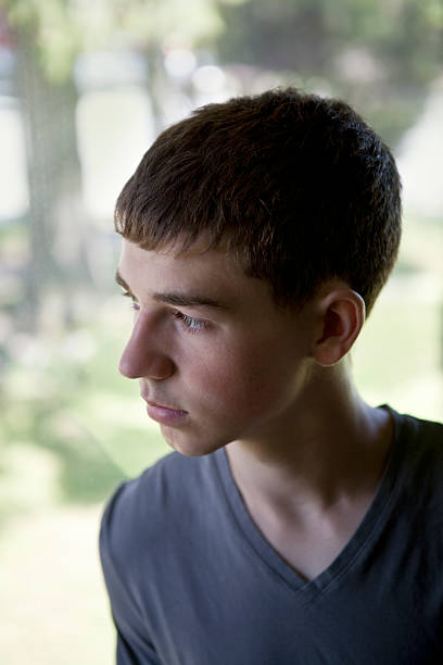 istock Teen Boy Looking out Large Window 184120873