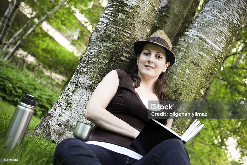 Student "Young woman working under the tree, beautiful summer day." 20-24 Years Stock Photo