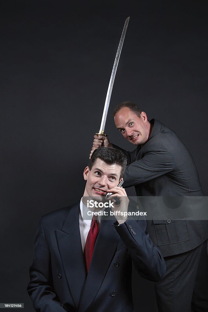 Business Betrayal "Sitting duck businessman unaware of attack from behind with a sword.For more business images, please click here:" Stabbed in the Back Stock Photo