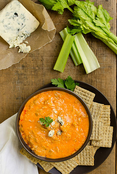 Buffalo Chicken Wing Dip from Above "Spicy Buffalo Chicken Wing Dip, made with chicken, blue cheese, cheddar cheese, hot sauce and celery.  Shot from directly above on a rustic wooden crate.Similar Images:" dipping sauce stock pictures, royalty-free photos & images