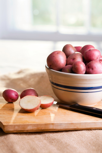 New Red potatoes on a cutting board and in a bowl