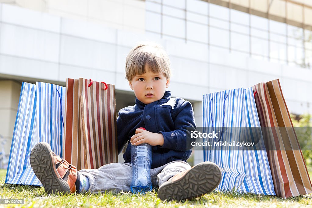 Bambino con le borse degli acquisti - Foto stock royalty-free di Abbigliamento