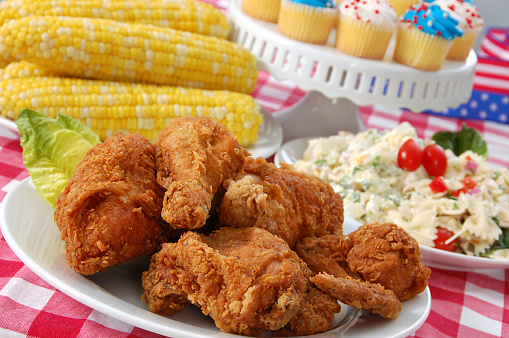 All the fixin's for a perfect Indepence Day picnic: fried chicken, corn on the cob, potato salad, pasta salad, and red, white, and blue cupcakes.