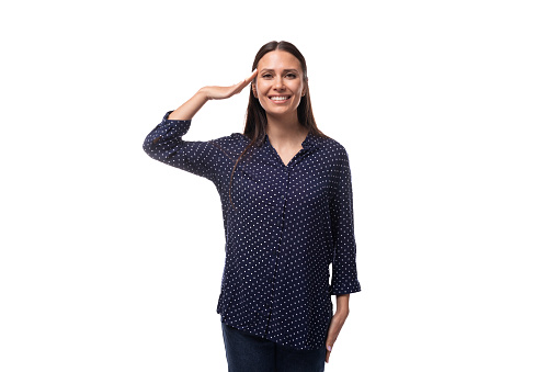 young brunette advertiser woman dressed in a blue blouse with a polka dot pattern says hello.