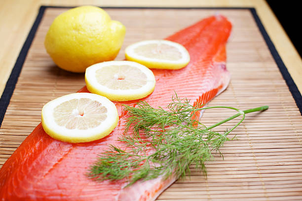 Wild Salmon raw fillet on bamboo Wild Sockeye Salmon fillet on bamboo with lemons and dill herb(photos professionally processed - Aperture / Photoshop - original size 5616 x 3744 Canon 5D MKII ) sockeye salmon filet stock pictures, royalty-free photos & images