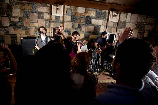 Indie band singing on stage in front of crowd stock photo