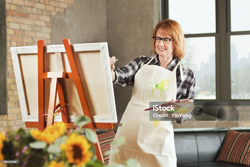 Mujer adulta Hobby pintura sobre lienzo apartamento hogar en el condominio - Foto de stock de 50-59 años libre de derechos