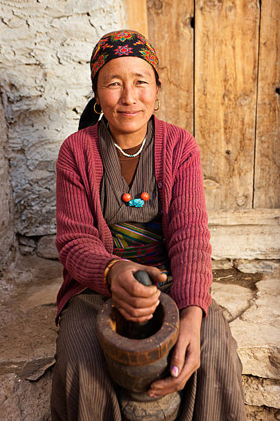 istock Tibetan woman using a mortar to make flour. Mustang, Nepal 184129258