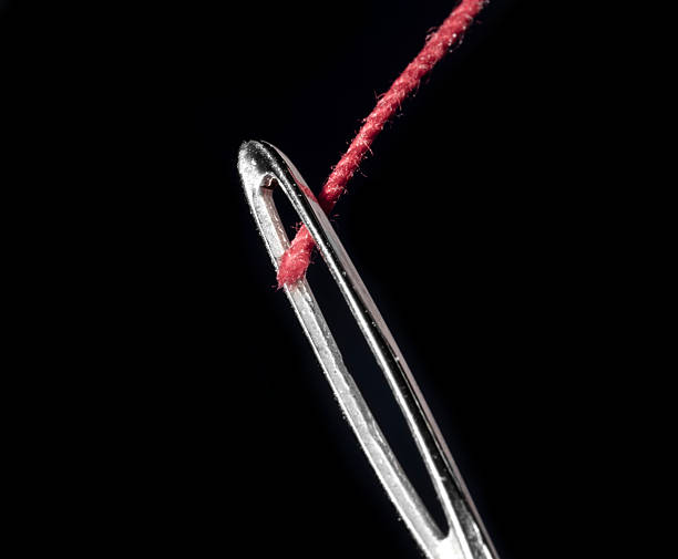 Textile: Red Thread and Needle Isolated on White Background