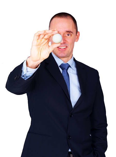 istock Smiling businessman showing a golfball against white 184129705