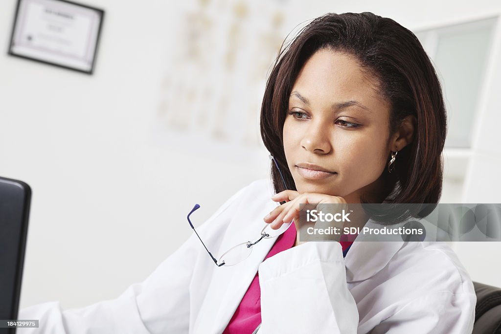 Jeune médecin se concentrer sur votre travail en Cabinet médical - Photo de Blouse de laborantin libre de droits