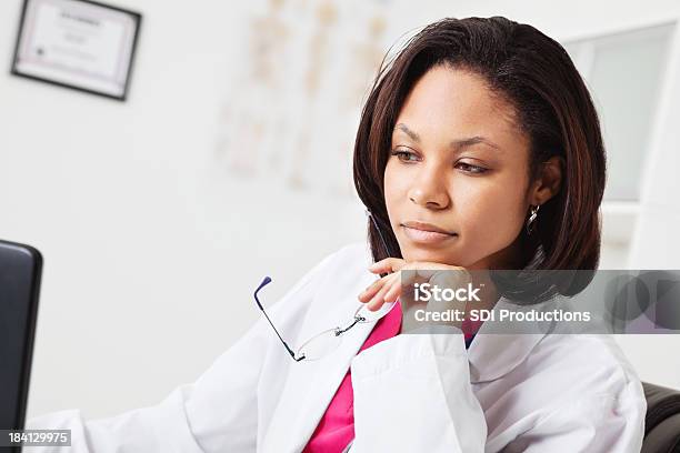 Giovane Medico Di Concentrarsi Sul Lavoro In Ufficio Del Medico - Fotografie stock e altre immagini di Camice da laboratorio