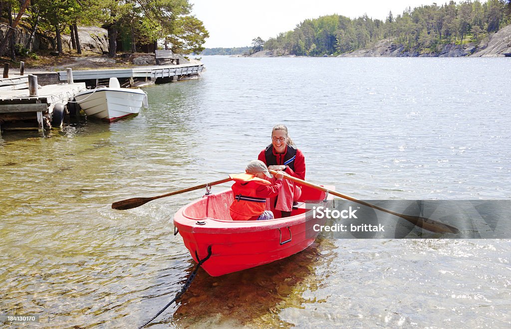 Madre e figlio in rosso piccola barca a remi. Arcipelago di Stoccolma. - Foto stock royalty-free di Bambini maschi