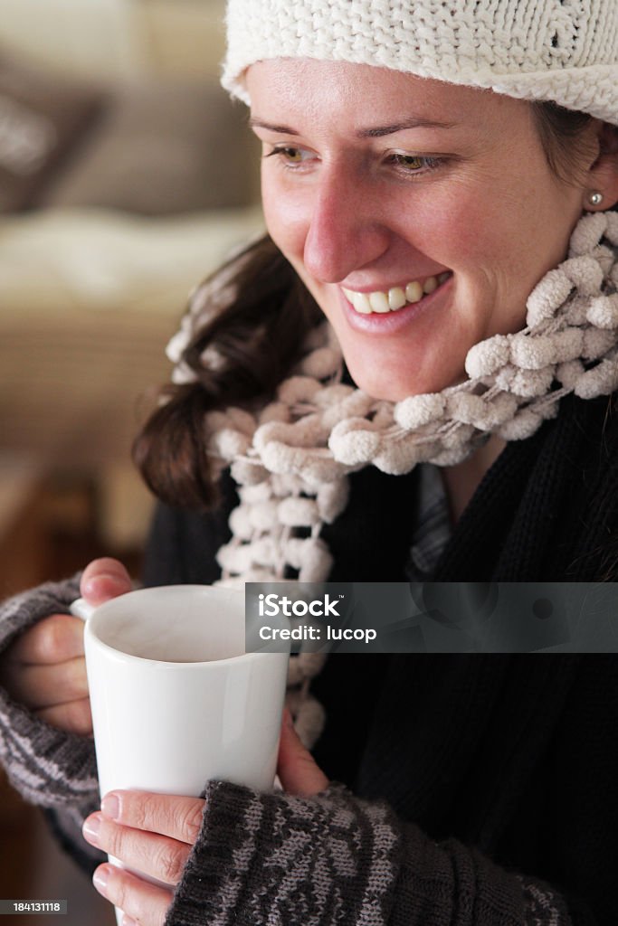 Giovane donna che indossa abiti bere tè caldo - Foto stock royalty-free di Abbigliamento casual