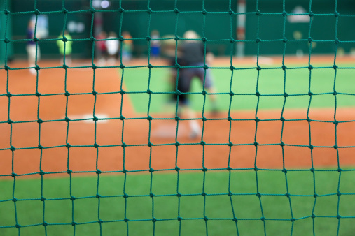 Indoors baseball field. Selective focus on a net.