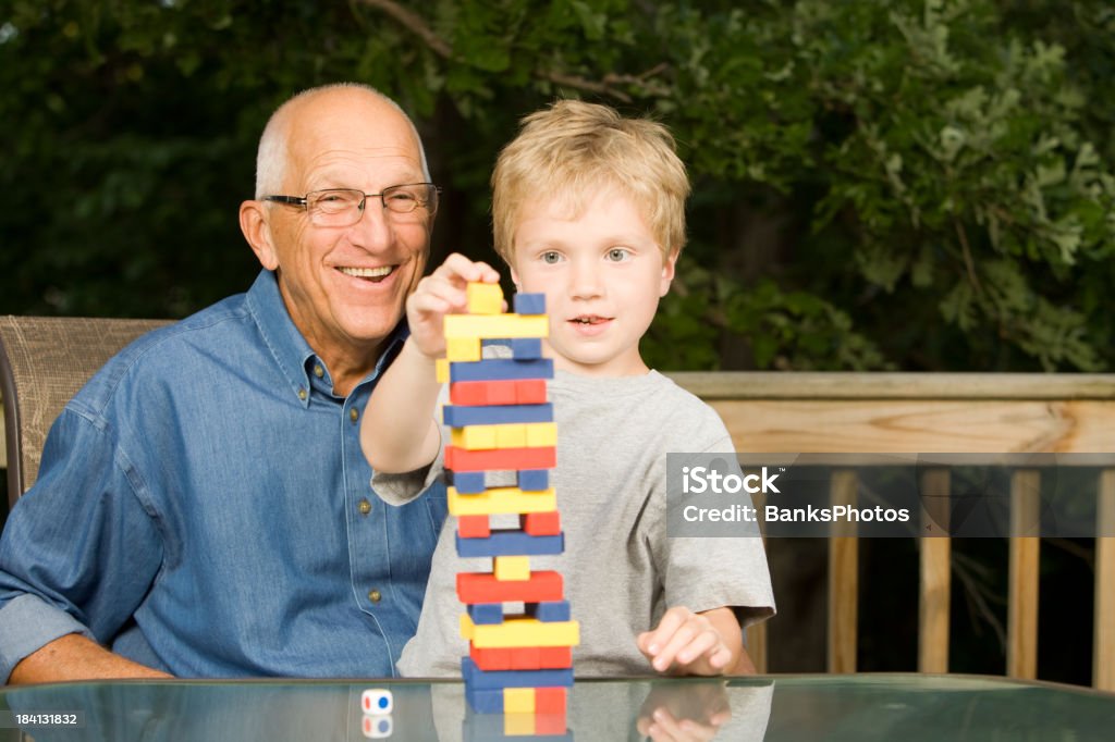Abuelo y nieto Play Tower de apilado de habilidad juego - Foto de stock de Bloque de construcción libre de derechos