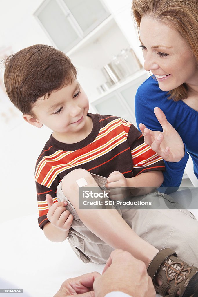 Jovem mãe ajudando o seu filho receba tratados em consultório médico - Royalty-free Filho Foto de stock