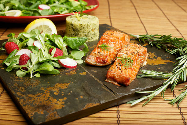 Slate tile plated grilled wild Salmon fillet arugula and couscous