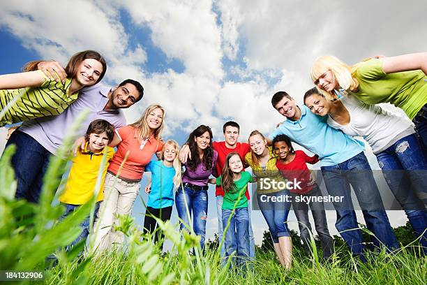 Allegro Gruppo Di Giovani Guardando La Telecamera - Fotografie stock e altre immagini di Cielo - Cielo, Gruppo multietnico, Abbracciare una persona