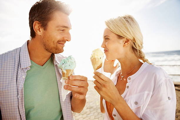 istock Young couple enjoying an ice cream on the beach 184133076